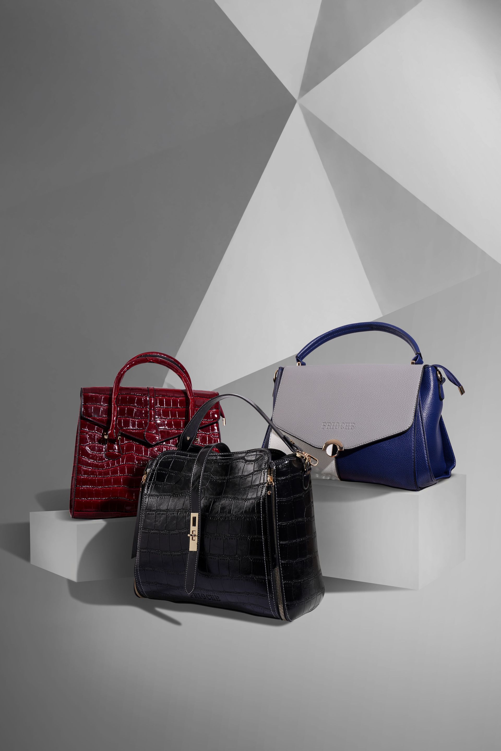 Stylish leather handbags displayed on a geometric studio background.